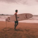 Surfer walking along the beach of Arugam Bay