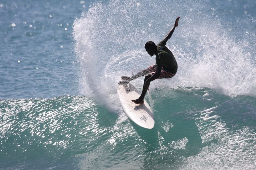 A professional surfer is catching the big waves of Arugam Bay